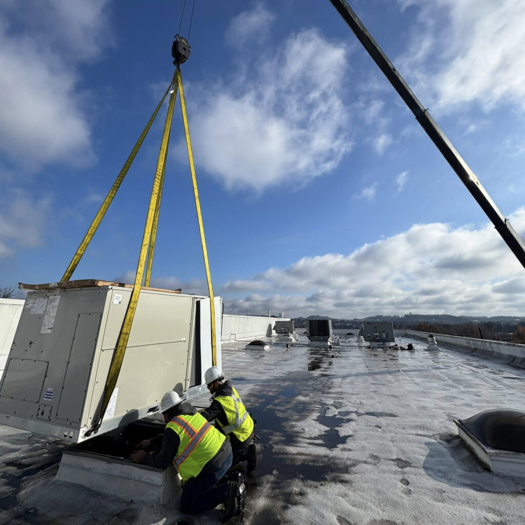 ventec commercial hvac installers positioning a roof top unit using a crane