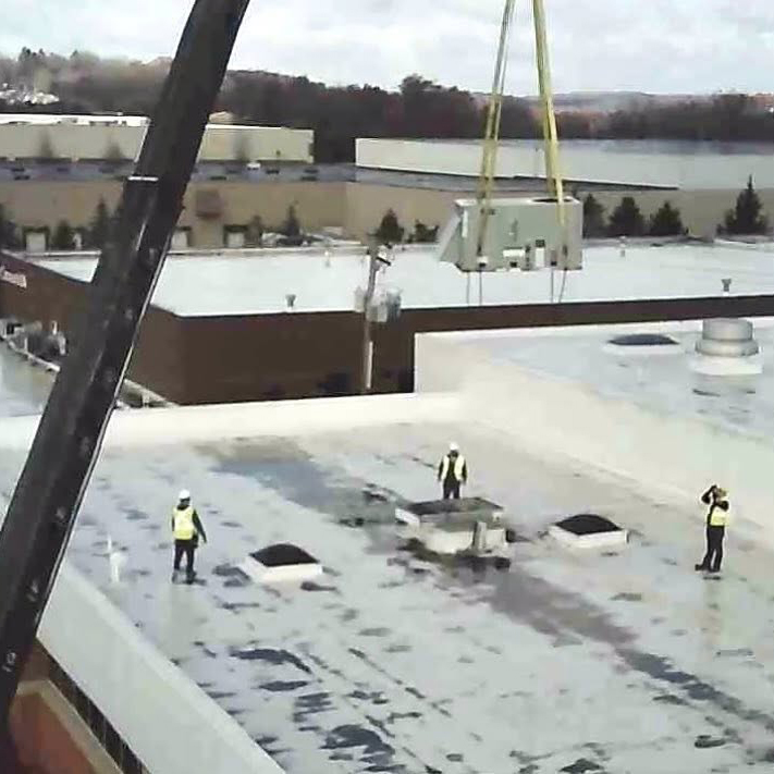 Crane lowering commercial rooftop hvac unit for ventec installers