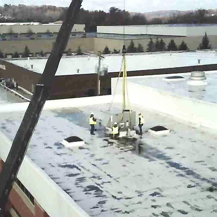 Crane lowering commercial rooftop hvac unit for ventec installers